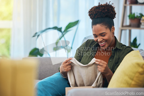 Image of Unboxing, clothes and happy woman on sofa in home, living room and excited for online shopping, package or product. African, fashion and person smile on couch with ecommerce clothing in house