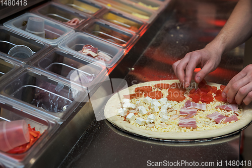 Image of making pizza at kitchen of pizzeria