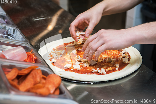 Image of making pizza at kitchen of pizzeria