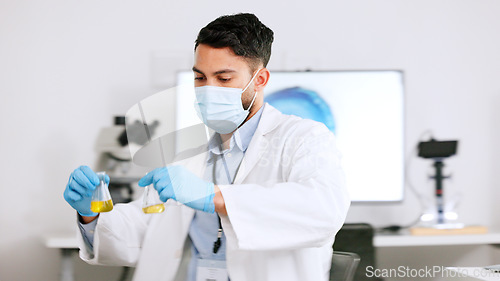 Image of Scientist and research or medical engineer doing experiments to create a cure in a lab while wearing a mask. Healthcare professional working with science equipment and writing notes in a laboratory