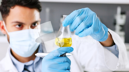 Image of A thinking young scientist doing research to create a covid cure in a lab. Medical professional using science equipment in a laboratory. A serious male healthcare worker working with a mask.