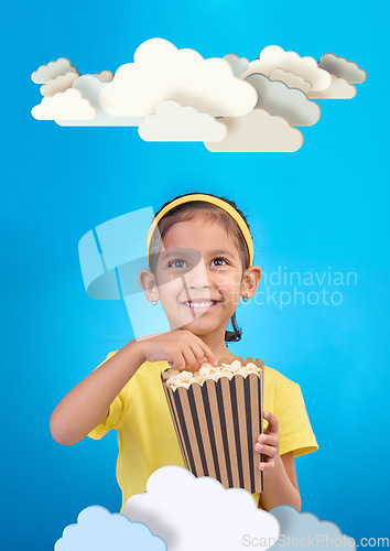 Image of Paper, cloud and girl child with popcorn in studio for cinema, fantasy or creative space on blue background. Kindergarten, lesson and kid with snack for movie, learning or creativity and television