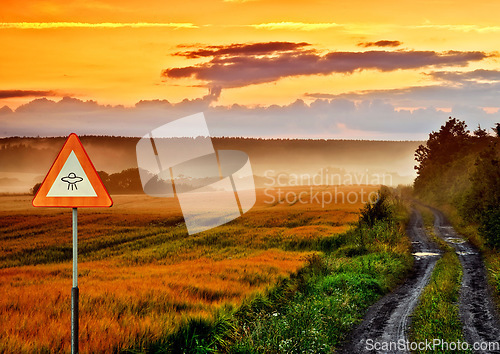 Image of Alien, spaceship sign and road in nature for UFO warning, science fiction and space abduction. Area 51, travel and signage for extraterrestrial caution in countryside, meadow and natural landscape