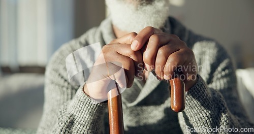 Image of Closeup, senior and hands of man with cane for support, walking help and aging. Morning, house and elderly person with gear for a walk on the living room sofa for healthcare and holding for strength