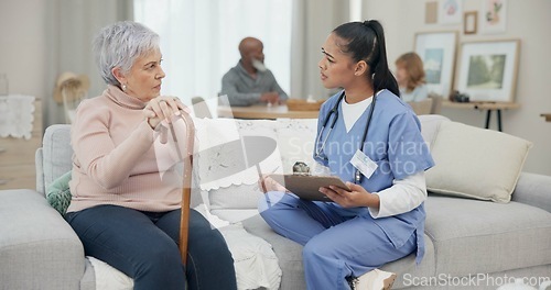 Image of Healthcare, consultation and nurse with senior woman in the living room of the retirement home. Medical, checkup and female caregiver speaking to elderly patient with walking cane in nursing facility