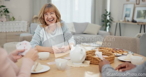 Image of Tea, happy and retirement with friends and playing cards in living room for relax, diversity and poker. Games, smile and community with group of old people in nursing home for party and celebration