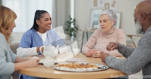 Image of Tea, happy and retirement with friends and playing cards in living room for relax, diversity and poker. Games, smile and community with group of old people in nursing home for party and celebration