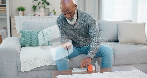 Image of Container, senior black man and organise pills tablet, health medication or pharmaceutical prescription. Home sofa, medical supplement drugs and African elderly person set daily healthcare medicine