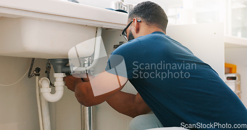 Image of Plumber black man, kitchen and sink maintenance with tools, focus and pipe repair for drainage in home. Entrepreneur handyman, plumbing expert or small business owner in house for fixing water system