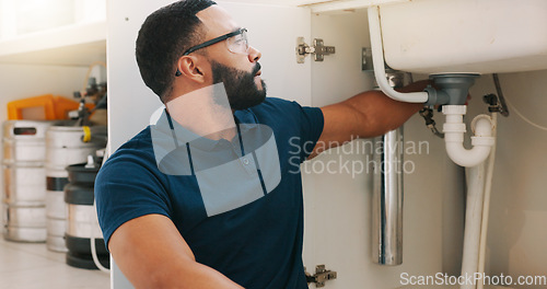 Image of Plumber black man, kitchen and sink maintenance with tools, focus and pipe repair for drainage in home. Entrepreneur handyman, plumbing expert or small business owner in house for fixing water system