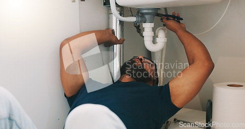 Image of Plumber black man, kitchen and sink maintenance with tools, focus and pipe repair for drainage in home. Entrepreneur handyman, plumbing expert or small business owner in house for fixing water system