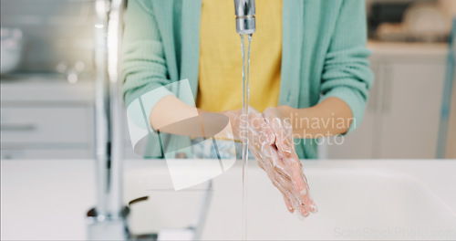 Image of Washing hands, woman and water from kitchen sink with soap for cleaning and wellness. Home, safety and virus protection of a person with sanitary healthcare in a house for skincare and grooming