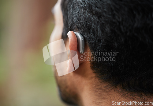 Image of Closeup of hearing aid, ear and man with disability from the back for medical support, listening and healthcare tech. Deaf patient, face and audiology implant to help volume, vibration or sound waves