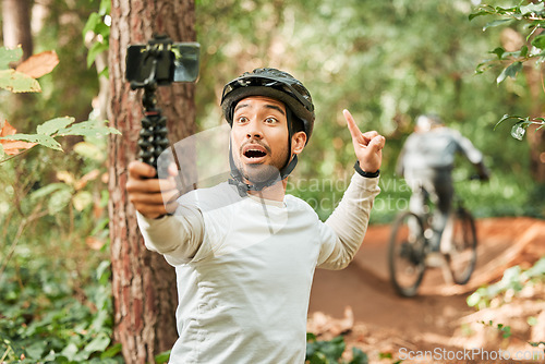Image of Cycling man, selfie and happy in forest, pointing and excited for wellness, training or blog on adventure. Influencer guy, helmet and smile in profile picture, memory or live stream on social network