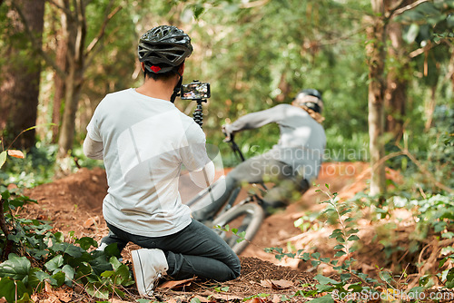 Image of Man, bike and forest with photographer, speed and phone for race, cycling video or post on web blog. Guy, bicycle and recording for vlog, live streaming or social media in woods for outdoor sports