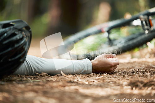 Image of Man, cycling and fall on forest trail from fitness, workout and training accident on bike lying on ground. Dirt road, woods and emergency of a athlete with injury from sport on a park path outdoor