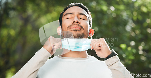 Image of Covid, Asian man and take off mask for end of pandemic, breathing and outdoor protected. Corona, healthy guy and Japanese person remove face cover for fresh air, freedom and decrease infection rates