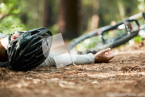 Image of Sports, fitness and cycling accident with a man on the ground while training for a race in the forest. Exercise, crash and fall with a cyclist unconscious in the woods during a nature workout closeup