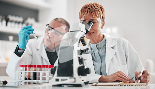 Image of Science, team and microscope for test in laboratory, medical investigation or healthcare innovation. Man, woman and biotechnology analysis for vaccine development, chemistry research and review notes