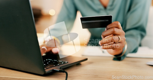 Image of Laptop, credit card and woman hands for business online shopping, transaction or fintech payment in night office. Professional black person typing her banking information on computer or financial app