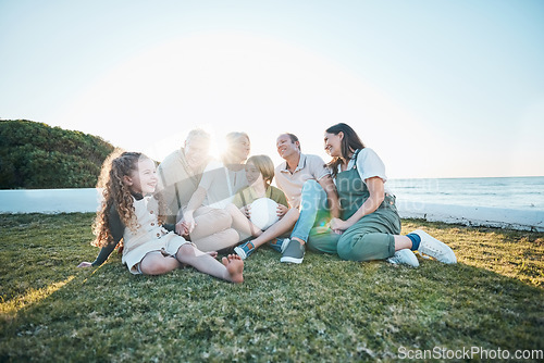 Image of Family, grandparents and children on grass by ocean for bonding, relationship and relax together. Nature, parents and happy grandmother, grandfather and kids on holiday, vacation and travel by sea