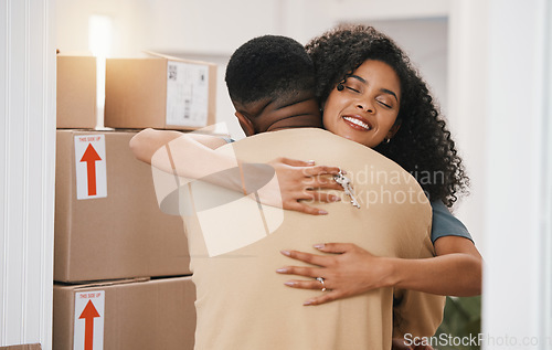 Image of Happy couple, hug and real estate in new home, moving in or boxes for investment or ownership together. Man and woman with keys in embrace for property, relocation or renovation in house mortgage