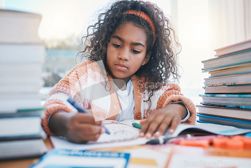 Image of Education, art and kid coloring in a book for artistic project, assignment or fun. Colors, crayon and girl child student writing for creative learning in a notebook for homework by a desk at home.