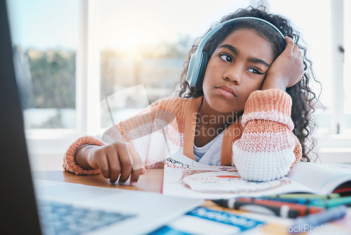 Image of Child, headphones and girl tired of home school, e learning and future online education. Thinking, bored and kid with ADHD, autism and sad at laptop while drawing and listening to audio at table