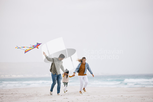 Image of Family, running and flying a kite at beach outdoor with fun energy, happiness and love in nature. Man and woman playing with a girl kid on holiday, freedom adventure or vacation at sea with banner