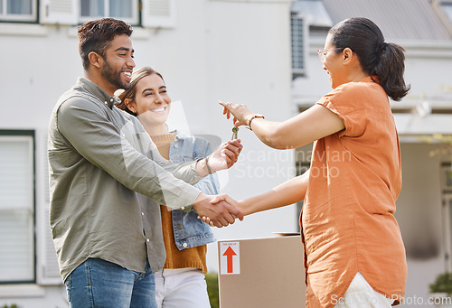 Image of Keys, realtor handshake and couple moving to new house, property investment and mortgage success, deal or thank you. Young people shaking hands and giving lock to dream home and real estate agreement