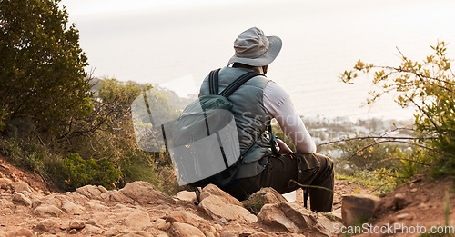 Image of Back, relax and view with a black man hiking in the mountains for travel, freedom or adventure in a remote location. Hike, break and scenic with a backpacker or hiker outdoor in nature to explore