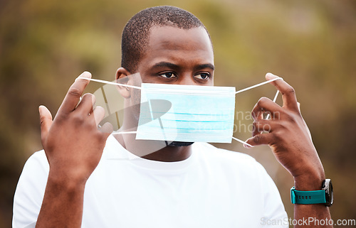 Image of Black man runner, mask and exercise outdoor on road for health, wellness or safety from covid 19 infection. Guy, medical ppe and cloth for virus, bacteria or freedom on countryside street in nature