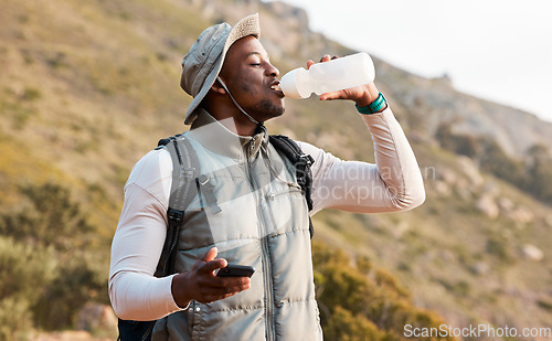 Image of Hiking, water bottle and black man with a smartphone, connection and hydration with fitness. African person, guy or hiker with a cellphone, mountain or thirsty with health, network or drinking liquid