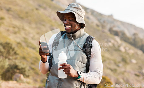 Image of Hiking, water bottle and black man with a cellphone, smile or hydration with fitness, travel or health. African person, guy or hiker with a smartphone, mountain or thirsty with exercise or connection