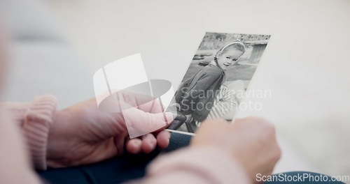 Image of Senior woman, holding and photo with memory with hands and remembering a child in closeup. Retirement, history and elderly person with retro picture in home with nostalgia or thinking about past.