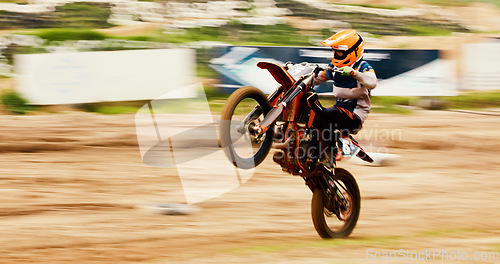 Image of Bike, balance and motion blur with a man on space at a race for a dirt biking challenge. Motorcycle, speed and power with a person driving fast on an off road course for freedom or performance