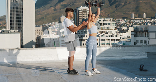 Image of Fitness, personal trainer and a woman outdoor with dumbbells for exercise, workout or training rooftop. Couple of friends in urban city for sports, strong muscle or bodybuilder and lifting weights