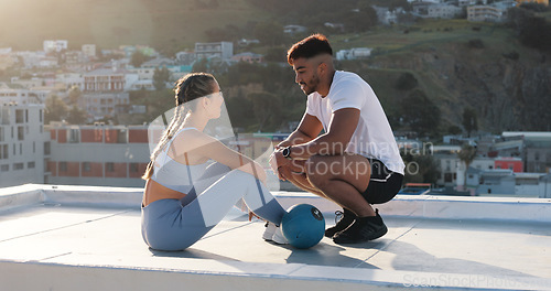 Image of Fitness, couple and outdoor to talk and rest for exercise, workout or training together on a city rooftop. Happy man and woman on sports break with medicine ball, communication and coach in Cape Town