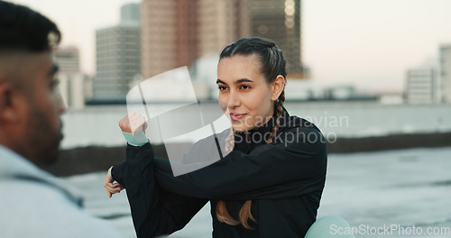 Image of Fitness, personal trainer and stretching on rooftop in city for exercise, sport or outdoor workout. Woman and man coaching in sports practice, body warmup or cardio together in an urban town