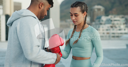 Image of Coach, woman and boxing gloves outdoor for training on rooftop in a city. Couple of friends, athlete and boxer with personal trainer man for martial arts workout, exercise and fight for combat sports