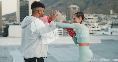 Image of Coach, boxing and woman outdoor for training on rooftop in a city. Couple of friends, athlete and boxer gloves with personal trainer man for martial arts workout, exercise and fight for combat sports