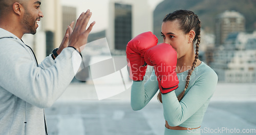 Image of Boxing, coach and woman outdoor for training on rooftop in a city. Couple of friends, athlete and boxer gloves with personal trainer man for martial arts workout, exercise and fight for combat sports