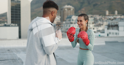 Image of Coach, boxing and woman outdoor for training on rooftop in a city. Couple of friends, happy athlete and boxer gloves with personal trainer man for martial arts workout, exercise and fight for sports