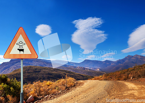 Image of Desert, sign and alien abduction in the mountains with a ufo warning along a dirt road on a blue sky. Nature, summer and and a route into area 51 with extraterrestrial signage on an empty landscape