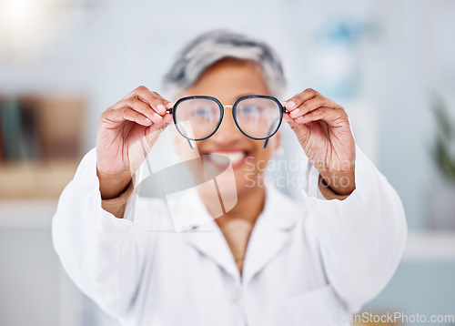 Image of Medical optician, woman and glasses for vision, eyesight and assessment of prescription lens. Hands of happy optometrist giving frame for eyewear, test and optical consulting eye care exam in clinic