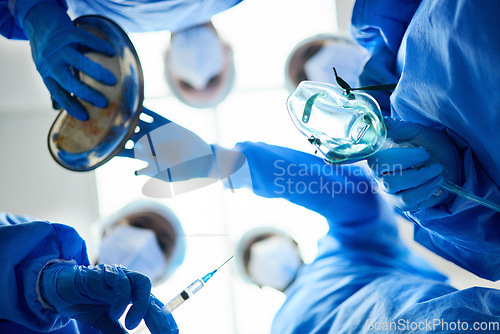 Image of Surgery team, below and a doctors in a hospital or theatre to start operation with anesthesia. Surgeon, assistant and medical group together for emergency healthcare with a oxygen mask and syringe