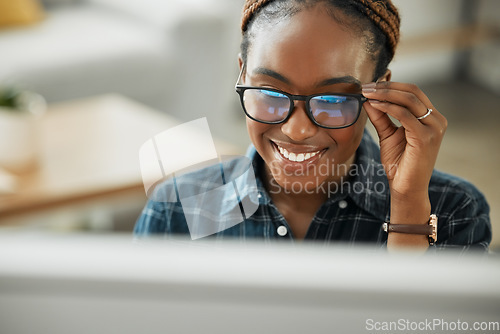 Image of Face, smile and computer with a black woman in glasses working closeup in her home for remote employment. Happy, website and desktop with a young employee at work on her small business startup