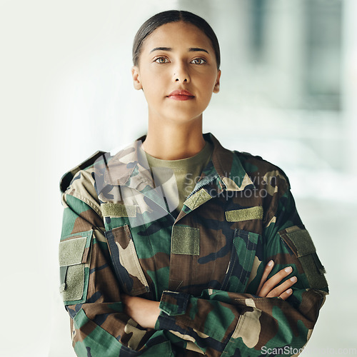 Image of Confident soldier portrait, woman and arms crossed in army building, pride and professional hero service. Military career, security and courage, proud girl in camouflage uniform at government agency.