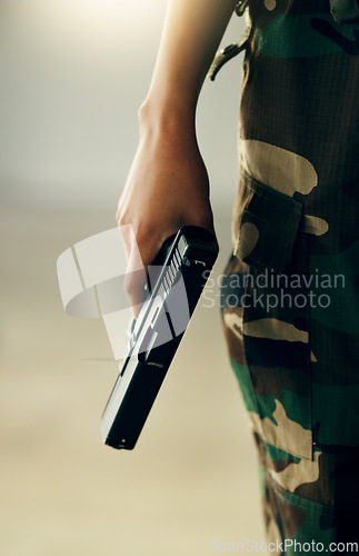 Image of Hand, gun and a soldier closeup on the battlefield during war or combat training for the military. Army, warrior or hero and a person in camouflage uniform with a pistol, firearm or weapon for safety