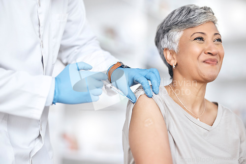 Image of Healthcare, vaccine and doctor with mature woman in consultation at hospital or clinic. Injection, syringe and happy patient with medical professional for vaccination for covid, insurance and care.